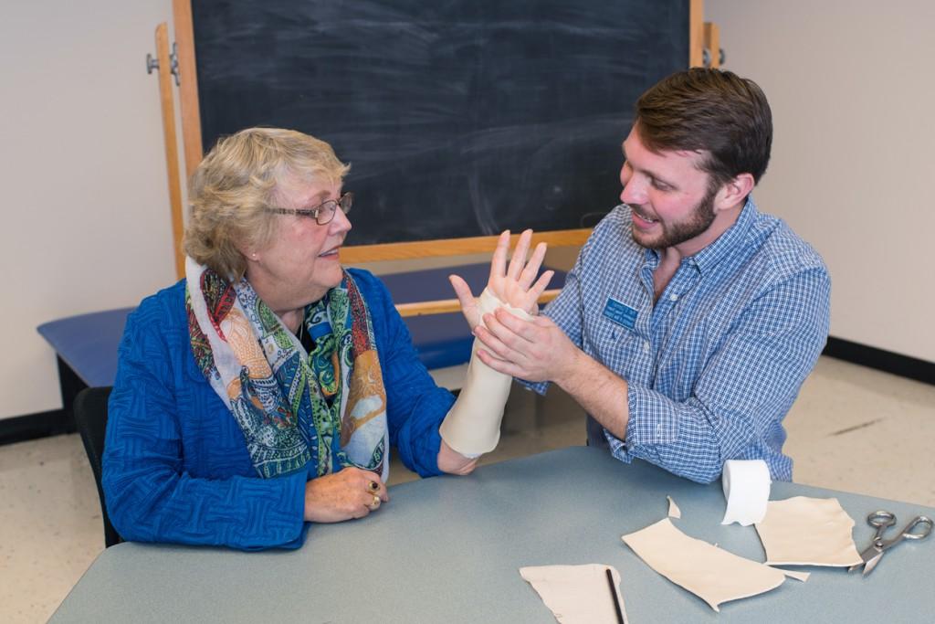 An occupational therapy student wraps the wrist of a patient