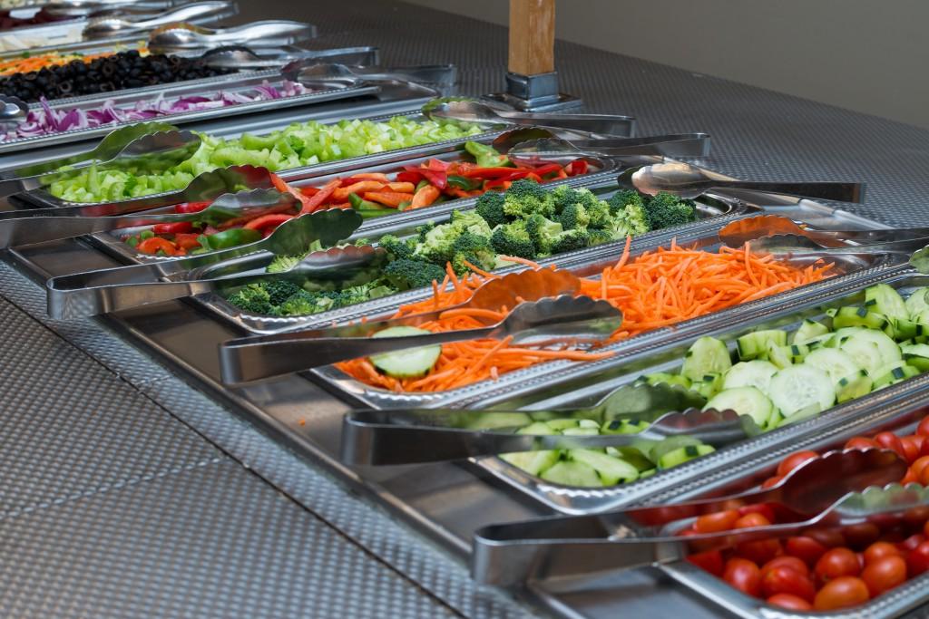 Peppers, cucumbers, carrots and other vegetables in the salad bar 