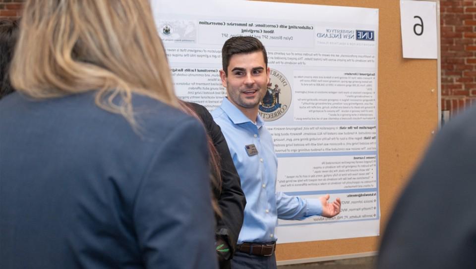 A doctor of physical therapy student presents their research poster at a symposium