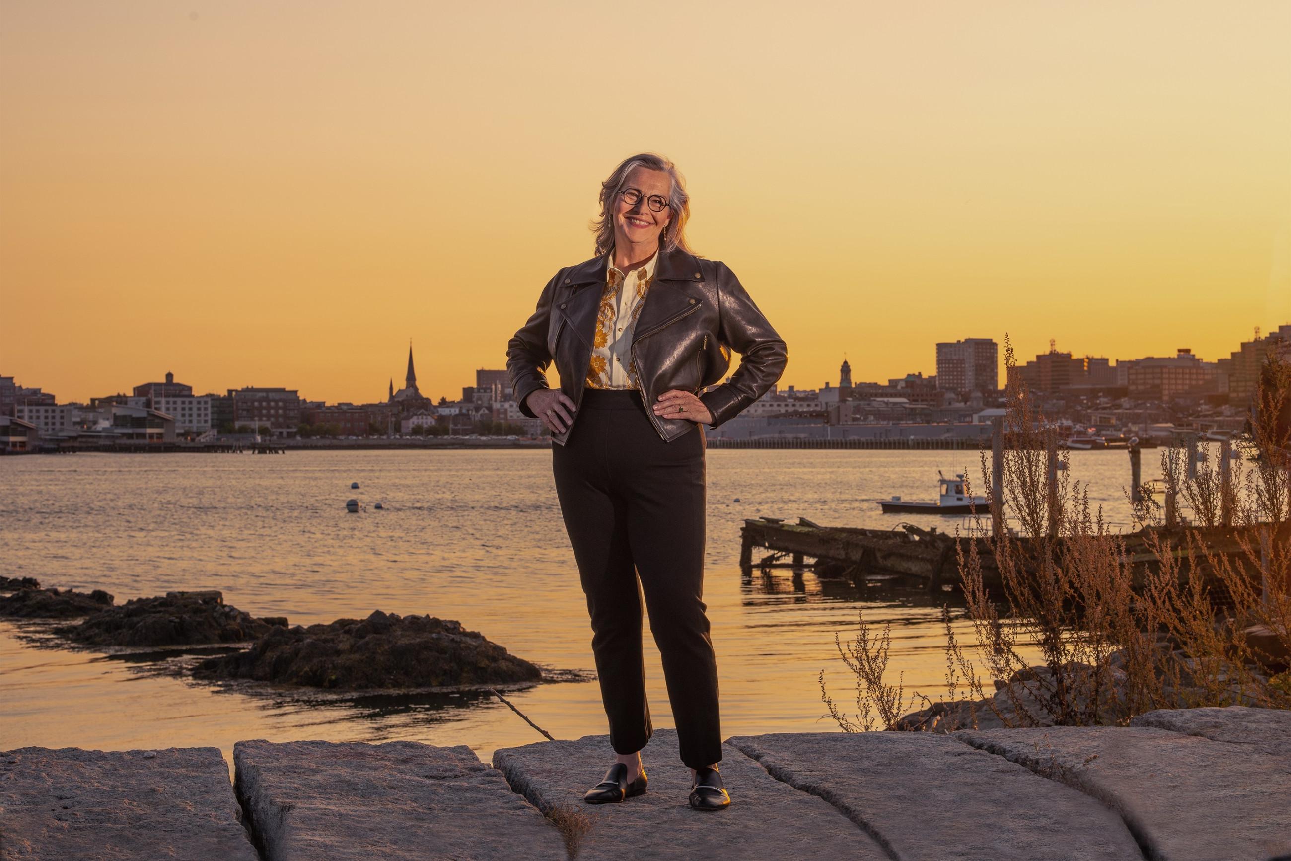 Karen Houseknecht standing infront of Casco Bay and the city of Portland